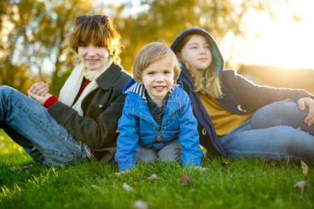 Photo for Two big sisters and their toddler brother having fun outdoors. Two young girls with a toddler boy on autumn day. Children with large age gap. Big age difference between siblings. Big family. - Royalty Free Image