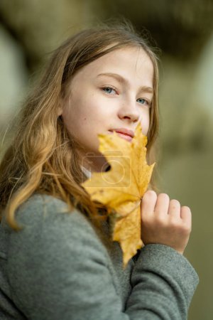 Foto de Adorable chica joven divirtiéndose en hermoso día de otoño. Feliz retrato adolescente en el parque de otoño. Actividades de otoño para niños. - Imagen libre de derechos
