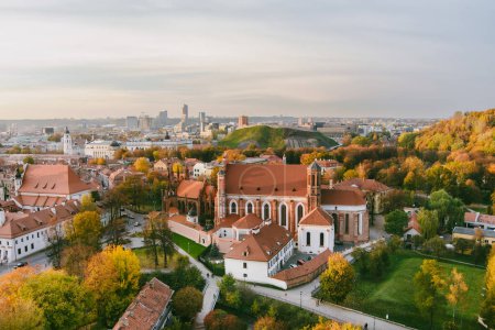 Téléchargez les photos : Vue aérienne de l'église Sainte-Anne et de l'église Bernardine voisine, l'un des bâtiments les plus beaux et probablement les plus célèbres de Vilnius. Belle journée d'automne dans la capitale de la Lituanie. - en image libre de droit