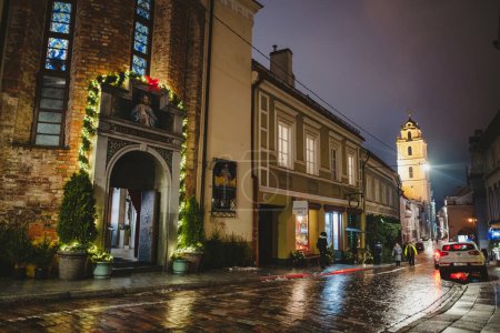 Photo for VILNIUS, LITHUANIA - DECEMBER 23, 2022: Narrow streets of Vilnius Old Town decorated for Christmas. Celebrating Christmas and New Year in Lithuanian capital. - Royalty Free Image