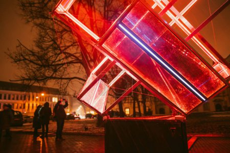 Foto de VILNIUS, LITHUANIA - 25 DE ENERO DE 2023: Instalaciones de iluminación escénica iluminadas por varios colores durante el Festival de la Luz de Vilna en el casco antiguo de la capital de Lituania. - Imagen libre de derechos