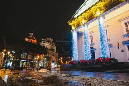 Foto de VILNIUS, LITUANIA - 23 DE DICIEMBRE DE 2022: Calles estrechas del casco antiguo de Vilna decoradas para Navidad. Celebración de Navidad y Año Nuevo en la capital lituana. - Imagen libre de derechos