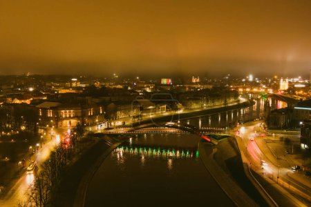 Scenic aerial view of Vilnius Old Town and Neris river at nightfall. Sunset landscape. Night view of Vilnius, Lithuania.