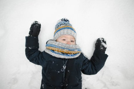 Photo for Cute toddler boy having fun on a walk in snow covered pine forest on chilly winter day. Child exploring nature. Winter activities for small kids. - Royalty Free Image