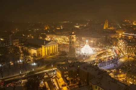 Photo for Beautiful aerial view of decorated and illuminated Christmas tree on the Cathedral Square at night in Vilnius. Celebrating Christmas and New Year in Lithuanian capital. - Royalty Free Image