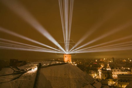 Foto de Vista aérea escénica de la torre de Gediminas en el casco antiguo de Vilna bellamente iluminada para la celebración del 700 cumpleaños. Símbolo principal de la capital lituana en la noche de invierno. - Imagen libre de derechos