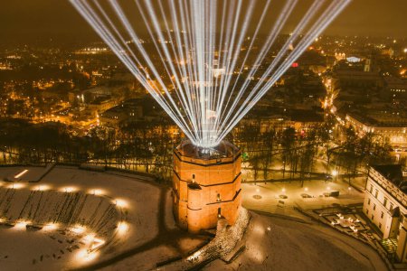 Scenic aerial view of Gediminas tower in Vilnius Old Town beautifully illuminated for 700th birthday celebration. Main symbol of Lithuanian capital at winter night.