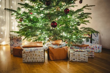 Téléchargez les photos : Beaux cadeaux de Noël sous l'arbre de Noël sur le sol dans le salon. Célébrer les vacances d'hiver à la maison. - en image libre de droit