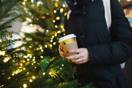Foto de Primer plano en las manos de una adolescente con una taza de café para llevar en el frío día de invierno. Adolescente niño bebiendo bebida caliente en el día frío. - Imagen libre de derechos