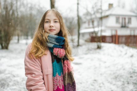 Téléchargez les photos : Adolescente mignonne s'amusant sur une promenade dans le parc de la ville le jour d'hiver froid. Adolescent explorant la nature. Activités hivernales pour les enfants. - en image libre de droit