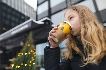 Téléchargez les photos : Adolescente mignonne avec tasse à café à emporter sur la journée froide d'hiver. adolescent gosse boire Chaud boisson sur froid jour. - en image libre de droit