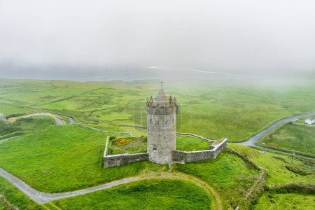 Aerial view of Doonagore Castle, round 16th-century tower house with a small walled enclosure located near the coastal village of Doolin in County Clare, Ireland.