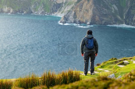 Tourist at Slieve League, Irelands highest sea cliffs, located in south west Donegal along this magnificent costal driving route. One of the most popular stops at Wild Atlantic Way route, Ireland.