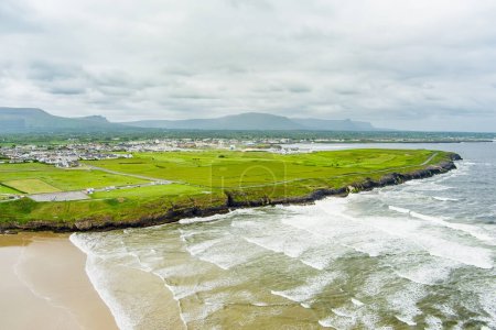 Foto de Espectacular Tullan Strand, una de las famosas playas de surf de Donegal, enmarcada por un pintoresco telón de fondo proporcionado por las montañas Sligo-Leitrim. Amplia playa de arena plana en el Condado de Donegal, Irlanda
. - Imagen libre de derechos
