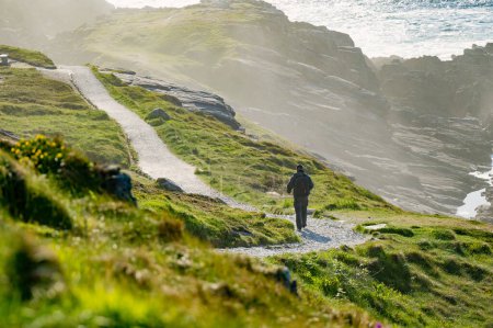 Foto de Turista admirando la belleza escénica de Malin Head, el punto más septentrional de Irlanda, Wild Atlantic Way, espectacular ruta costera. Maravillas de la naturaleza. Numerosos puntos de descubrimiento. Co. Donegal - Imagen libre de derechos
