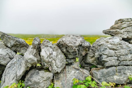 Téléchargez les photos : Célèbre mur irlandais de pierres sèches, construit avec une variété de pierres pour séparer et protéger les champs de cultures ainsi que de créer des champs séparés pour le pâturage du bétail. - en image libre de droit