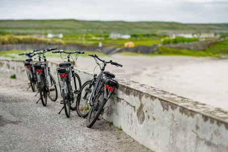 Foto de Bicicletas eléctricas estacionadas en Inishmore, la más grande de las Islas Aran en Galway Bay, Irlanda. Alquilar una bicicleta es una de las formas más populares de moverse por Inis Mor. - Imagen libre de derechos