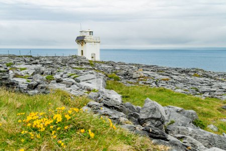 Black Head Lighthouse, situated in the rough rocky landscape of Burren, amidst a bizarre scenery of steep limestone mountains and rocky coastline, County Clare, Ireland.