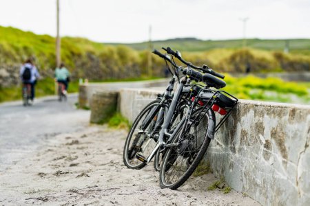 Foto de Dos bicicletas eléctricas estacionadas en Inishmore, la más grande de las Islas Aran en Galway Bay, Irlanda. Alquilar una bicicleta es una de las formas más populares de moverse por Inis Mor. - Imagen libre de derechos