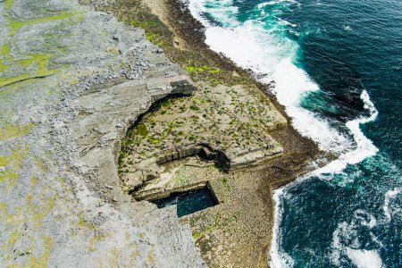Photo for Aerial view of famous Poll na bPeist or the Wormhole. Natural rectangular shaped pool at the bottom of the cliffs, south of Dun Aonghasa. Also known as The Serpents Lair. Inishmore. - Royalty Free Image