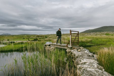 Schöne nebelige Aussicht auf die Screebe Fischerhütte, die in der Connemara Region in Irland liegt. Landschaftlich reizvolle Landschaft mit Bergen am Horizont, County Galway, Irland.