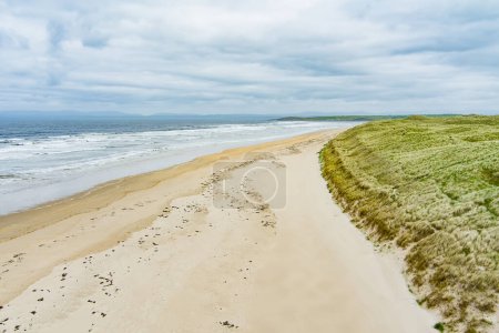 Téléchargez les photos : Spectaculaire Tullan Strand, l'une des célèbres plages de surf de Donegal, encadrée par une toile de fond pittoresque fournie par les montagnes Sligo-Leitrim. Large plage de sable plat dans le comté de Donegal, Irlande
. - en image libre de droit