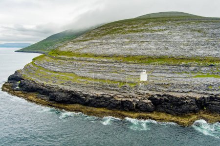 Foto de Black Head Lighthouse, situado en el áspero paisaje rocoso de Burren, en medio de un extraño paisaje de escarpadas montañas de piedra caliza y costa rocosa, Condado de Clare, Irlanda. - Imagen libre de derechos