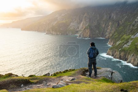 Foto de Turista en Slieve League, Irlanda acantilados más altos del mar, situado en el suroeste de Donegal a lo largo de esta magnífica ruta de conducción costera. Una de las paradas más populares en la ruta Wild Atlantic Way, Irlanda. - Imagen libre de derechos