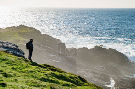 Téléchargez les photos : Touriste admirant la beauté pittoresque de Malin Head, point le plus au nord de l'Irlande, Wild Atlantic Way, route côtière spectaculaire. Merveilles de la nature. De nombreux points de découverte. Co. Donegal - en image libre de droit