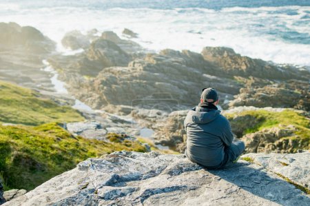 Turista admirando la belleza escénica de Malin Head, el punto más septentrional de Irlanda, Wild Atlantic Way, espectacular ruta costera. Maravillas de la naturaleza. Numerosos puntos de descubrimiento. Co. Donegal