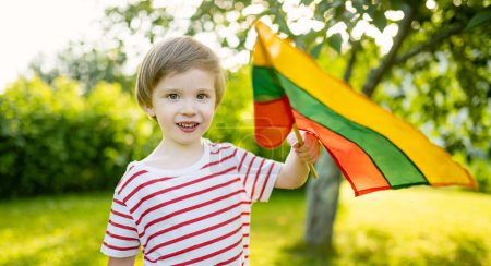 Mignon petit garçon tenant le drapeau tricolore lituanien le Jour de l'Etat lituanien, Vilnius, Lituanie