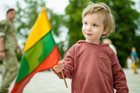 Cute little boy holding tricolor Lithuanian flag on Lithuanian Statehood Day, Vilnius, Lithuania