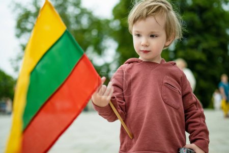 Mignon petit garçon tenant le drapeau tricolore lituanien le Jour de l'Etat lituanien, Vilnius, Lituanie