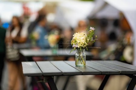 Foto de Mesa de restaurante al aire libre bellamente decorada con plantas y flores en Vilna, Lituania, en un bonito día de verano. - Imagen libre de derechos