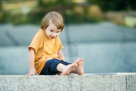 Photo for Funny little boy having fun in the city on sunny summer day. Outdoor summer activities for small kids. - Royalty Free Image