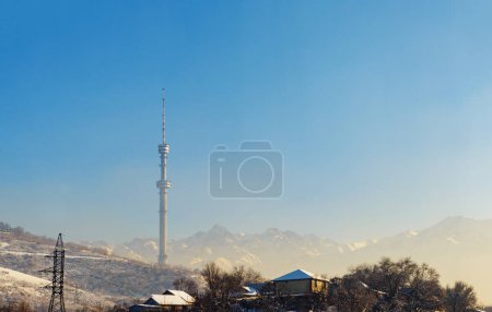 Almaty Television Tower and mountain view during winter smog. Smog is often formed in Almaty due to landscape imperfections. Kazakhstan