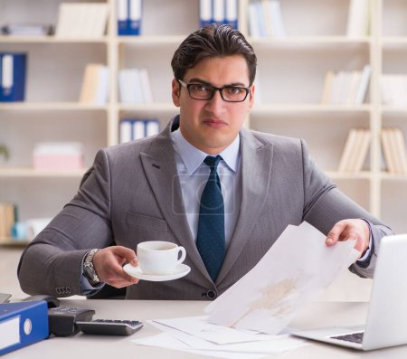 Photo for The businessman spilling coffee on important documents - Royalty Free Image