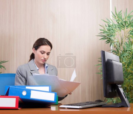 Foto de La ocupada mujer de negocios en la oficina bajo estrés - Imagen libre de derechos