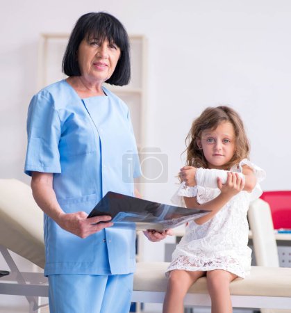 Photo for The little girl visiting old female doctor - Royalty Free Image