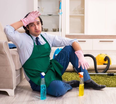 Téléchargez les photos : Le jeune homme d'affaires nettoie la maison - en image libre de droit