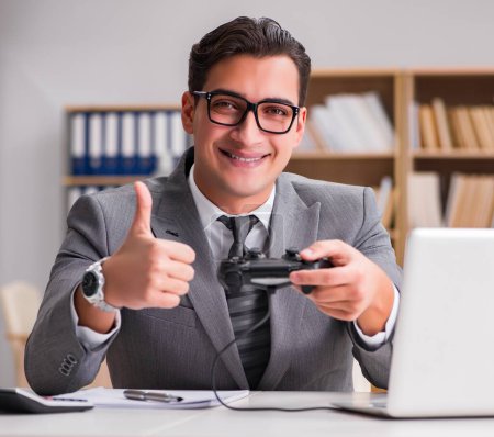 Téléchargez les photos : L'homme d'affaires jouant à des jeux informatiques au bureau - en image libre de droit