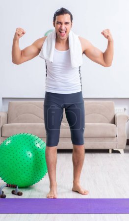 Photo for The young man training and exercising at home - Royalty Free Image