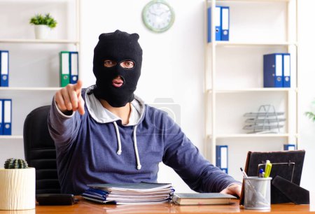 Téléchargez les photos : Le voleur masculin dans la cagoule dans le bureau - en image libre de droit