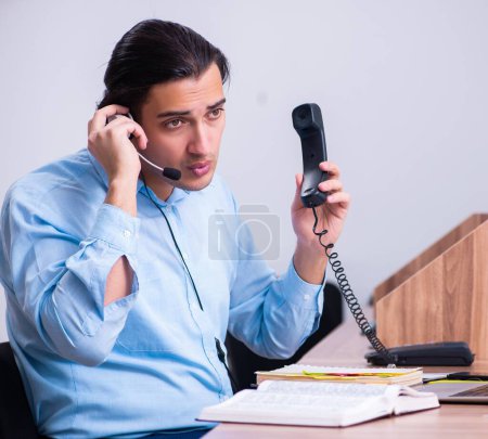 Téléchargez les photos : L'opérateur du centre d'appels travaillant à son bureau - en image libre de droit