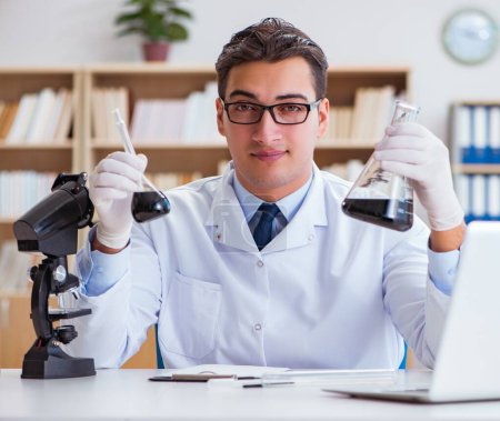 Téléchargez les photos : L'ingénieur chimiste travaillant sur des échantillons d'huile en laboratoire - en image libre de droit