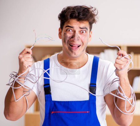 Photo for The funny man doing electrical repairs at home - Royalty Free Image