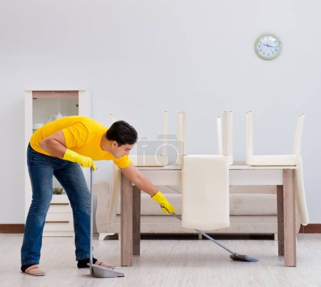 Téléchargez les photos : L'homme qui nettoie la maison aide sa femme - en image libre de droit