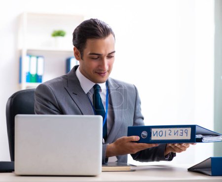 Téléchargez les photos : Le jeune comptable masculin travaillant dans le bureau - en image libre de droit