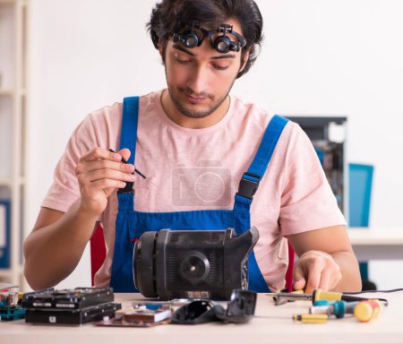 Photo for The young male contractor repairing computer - Royalty Free Image