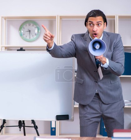 Photo for The young businessman standing in front of white board - Royalty Free Image